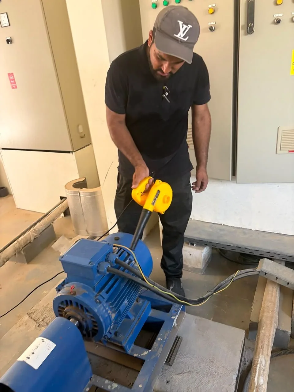 Technician servicing a pump motor in a plant room
