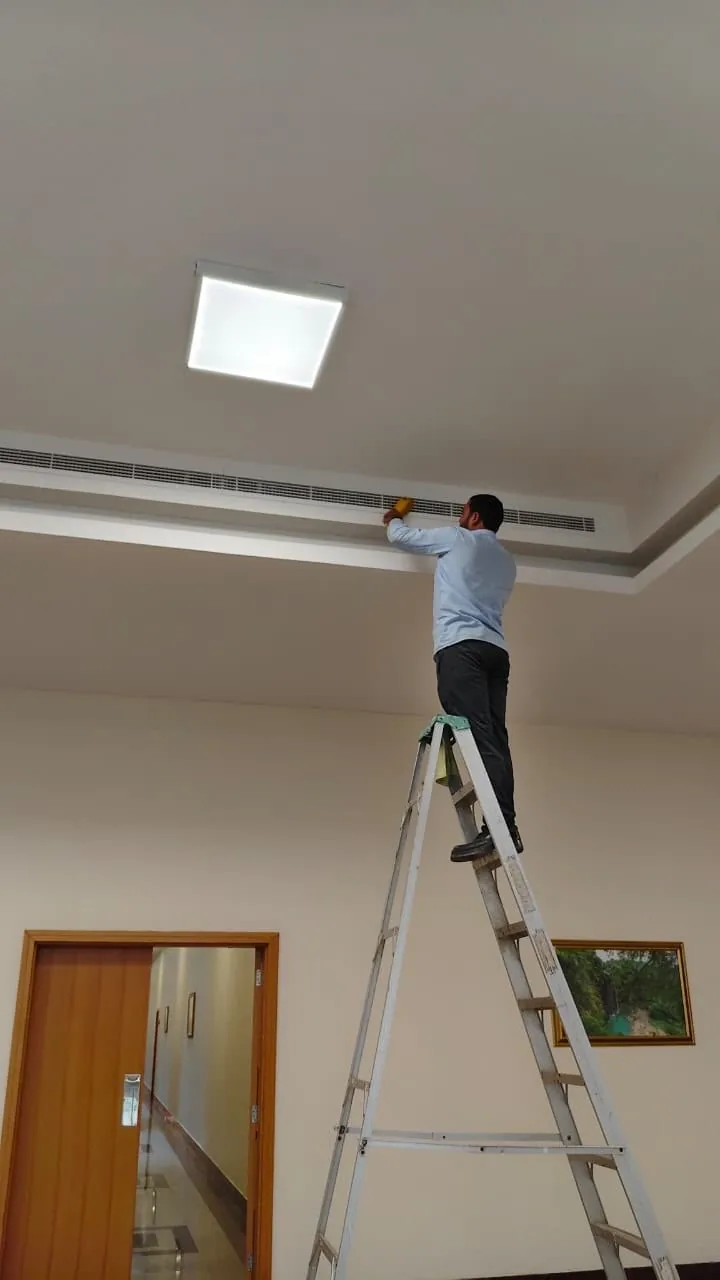 Technician working at a ceiling air outlet